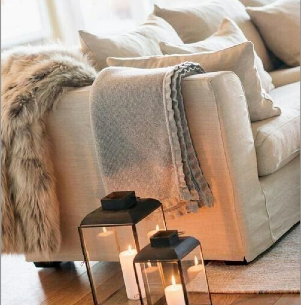 Detail of soft animal hide draped over a linen sofa