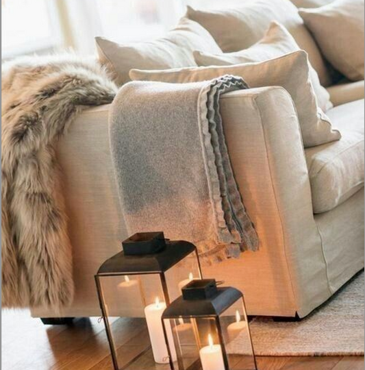 Detail of soft animal hide draped over a linen sofa